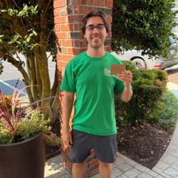 a man with a green shirt holding a piece of paper