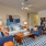 Spacious and well lit living room with wood flooring, large windows and open access to the kitchen